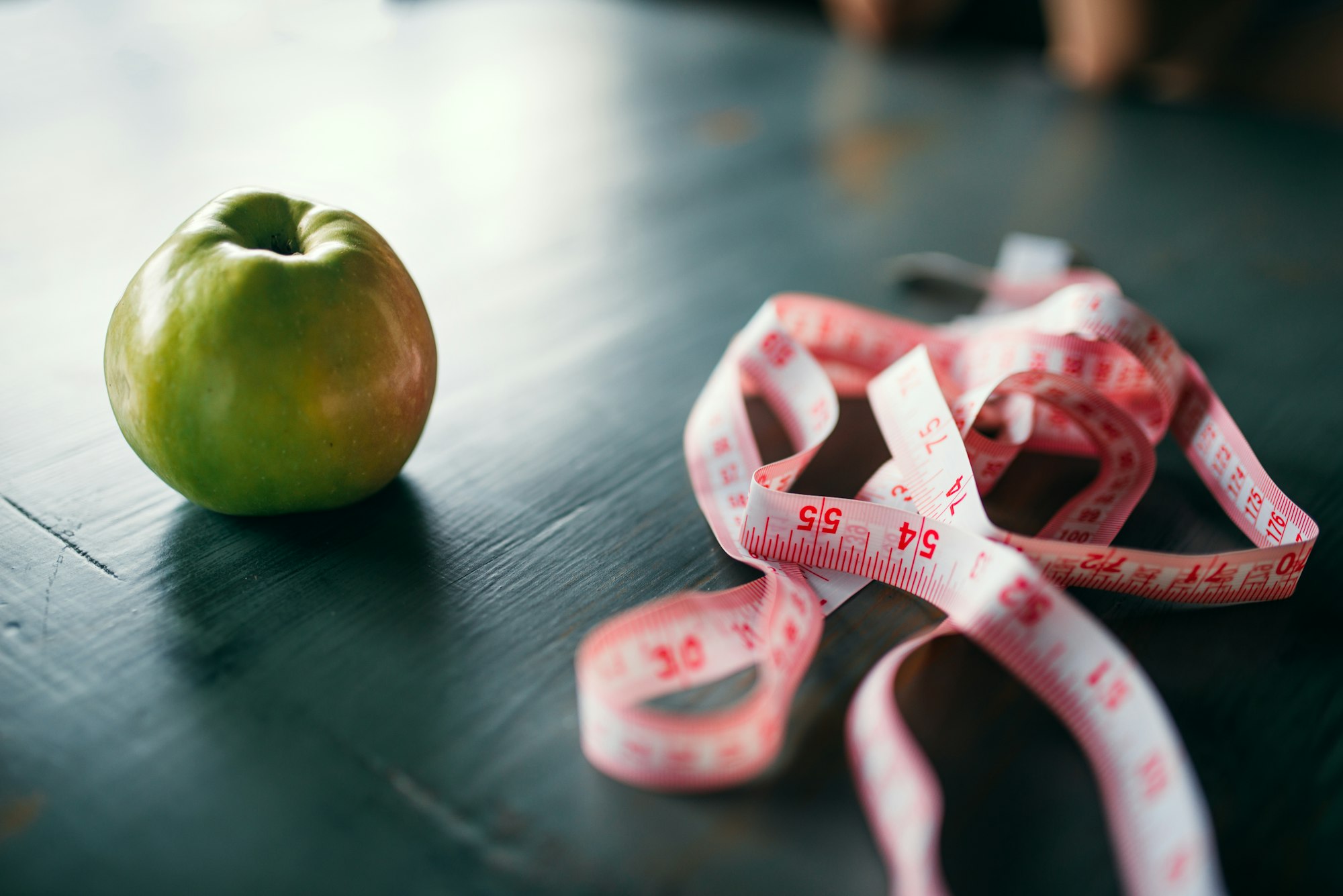 Apple and pink measuring tape, weight loss concept